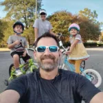 Jay and his family beaming with smiles while enjoying an outdoor biking adventure, showcasing their shared joy and love for outdoor activities.