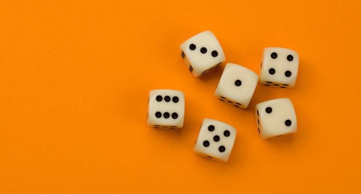 Dice arranged on an orange background, showcasing a game of chance, probability, and recreational entertainment.