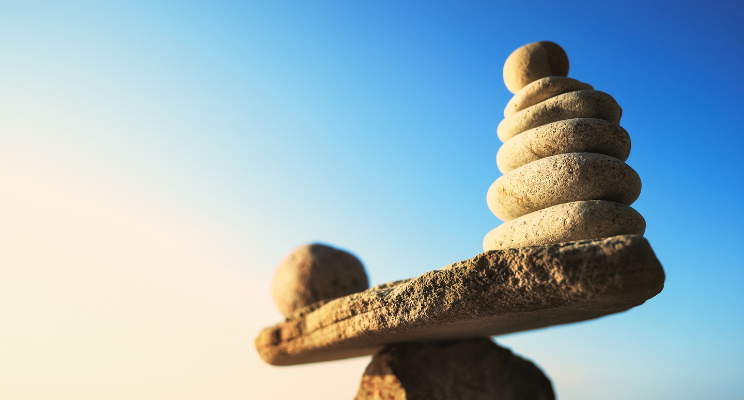A stack of rocks on either side, with one rock perfectly balanced on top of another rock, showcasing a harmonious and precarious arrangement.