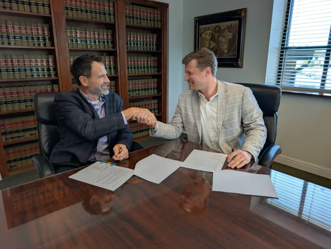 Marshall Dearing shaking hands after signing his partnership agreement at Vector Wealth Strategies